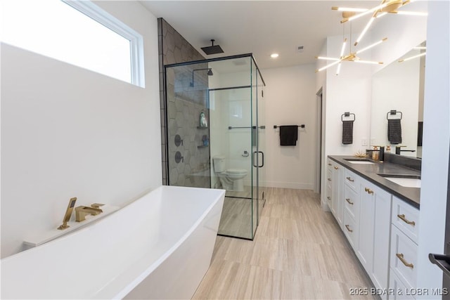 full bathroom with toilet, vanity, an inviting chandelier, and plus walk in shower