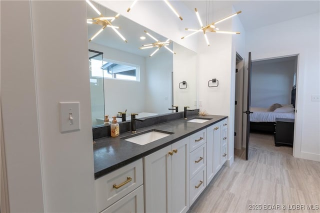 bathroom featuring hardwood / wood-style floors, vanity, and a notable chandelier