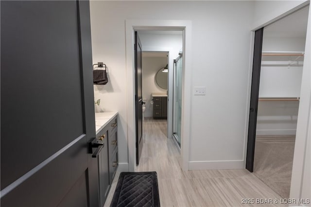 bathroom with a shower with door and vanity