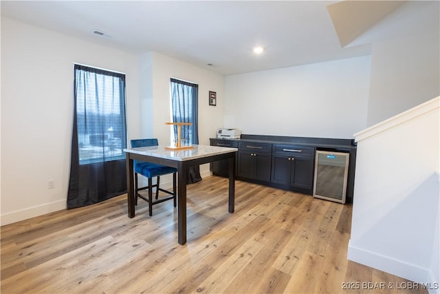 bar with light wood-type flooring and wine cooler