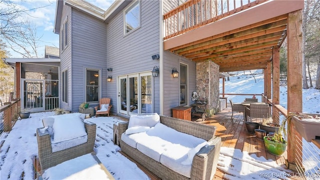 snow covered patio featuring a deck