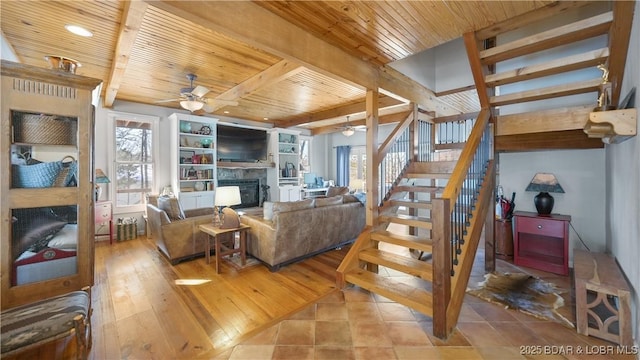 living room with ceiling fan, beamed ceiling, wood ceiling, and light wood-type flooring