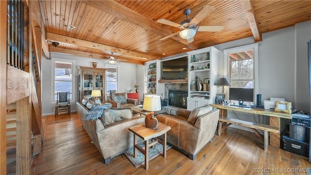 living room featuring wooden ceiling, wood-type flooring, built in features, and beam ceiling