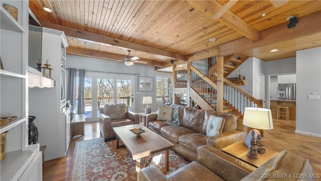 living room featuring wood ceiling, a ceiling fan, stairs, beamed ceiling, and wood finished floors