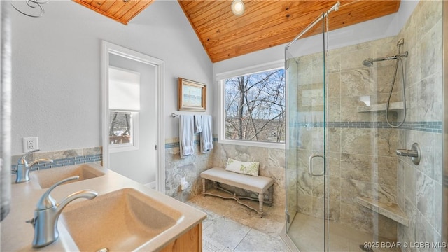 full bathroom featuring wood ceiling, lofted ceiling, a stall shower, and a sink