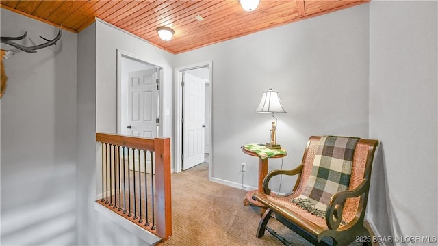 living area with wood ceiling and light colored carpet