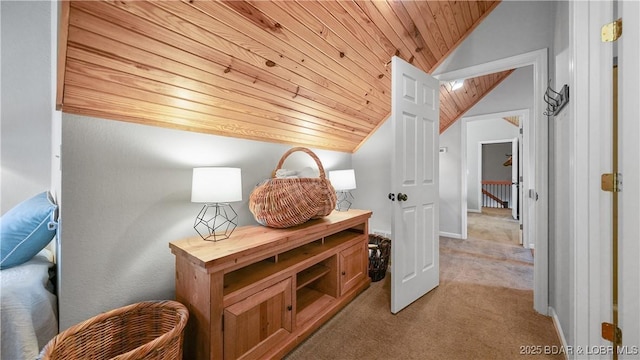 corridor featuring vaulted ceiling, wooden ceiling, and light colored carpet