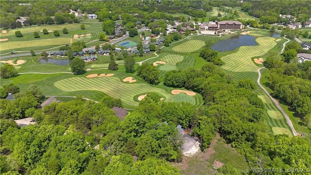 aerial overview of property's location featuring a nearby body of water, a tree filled landscape, and a golf club
