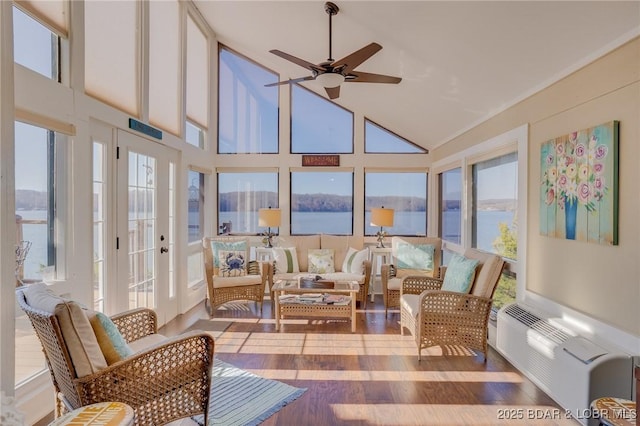 sunroom with a ceiling fan, lofted ceiling, and a wall mounted AC