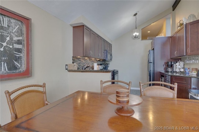 dining area featuring vaulted ceiling, sink, and an inviting chandelier