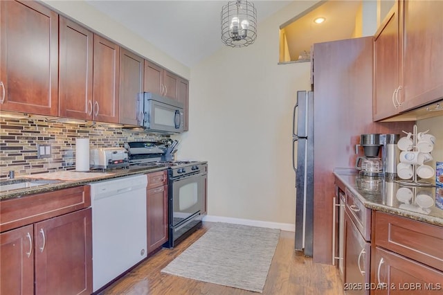 kitchen featuring black gas range oven, decorative backsplash, white dishwasher, refrigerator, and light hardwood / wood-style flooring