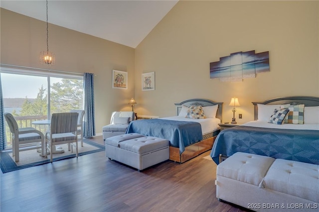 bedroom with dark wood-type flooring, an inviting chandelier, and high vaulted ceiling