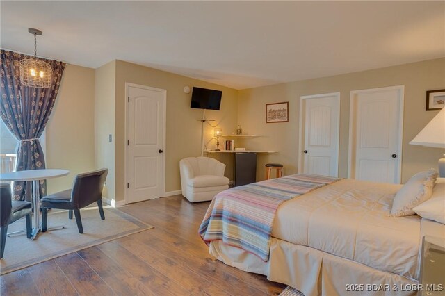 bedroom featuring hardwood / wood-style flooring and a notable chandelier