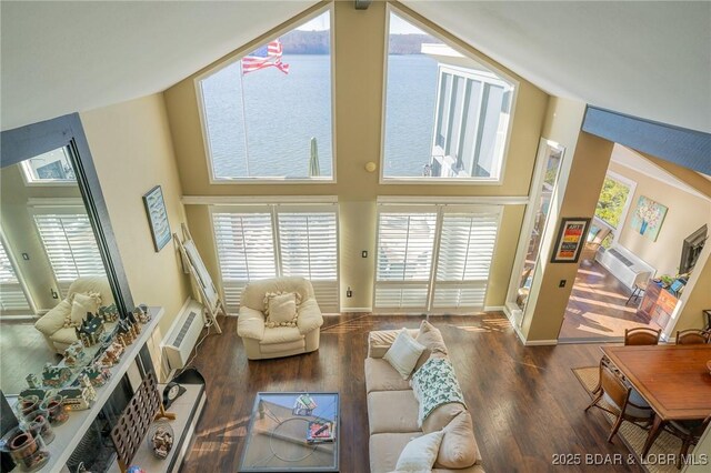 living room with a water view, dark hardwood / wood-style flooring, and a high ceiling