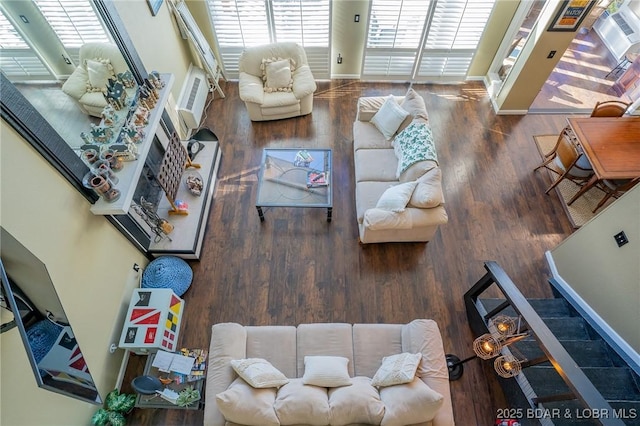 living room with a wealth of natural light, a wall mounted AC, and hardwood / wood-style flooring