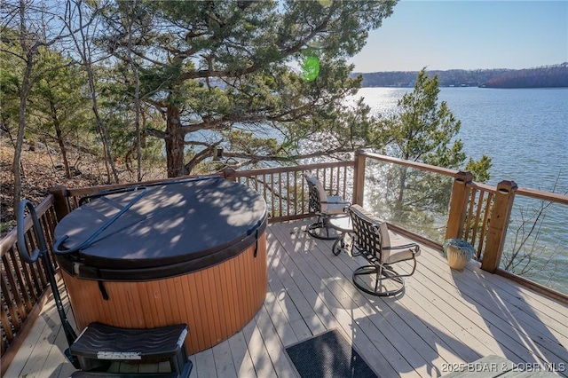 deck featuring a water view, a hot tub, and a grill