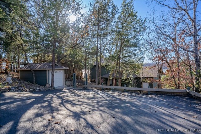 view of front of house featuring a garage and an outbuilding