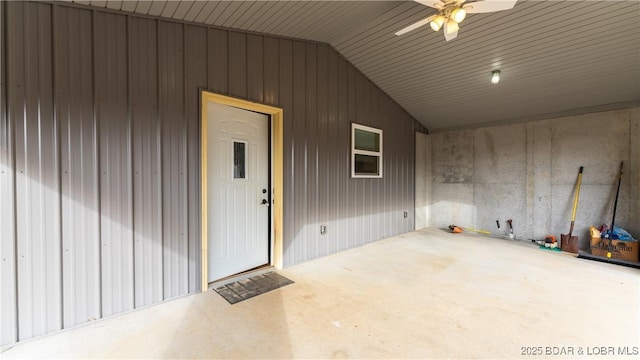 view of exterior entry with ceiling fan and a patio