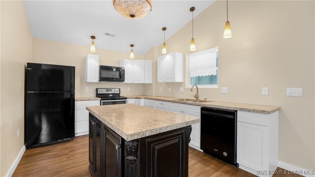 kitchen featuring black appliances, lofted ceiling, a kitchen island, white cabinetry, and sink