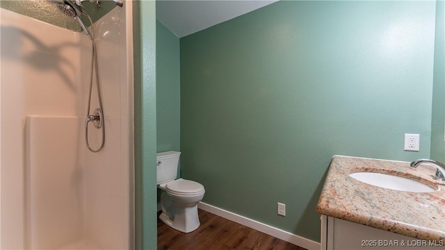 bathroom with toilet, vanity, walk in shower, and hardwood / wood-style floors