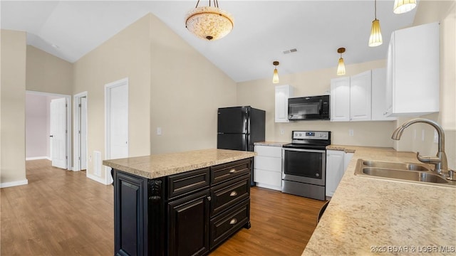 kitchen featuring wood-type flooring, sink, decorative light fixtures, black appliances, and white cabinets