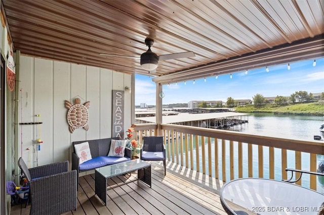 deck featuring ceiling fan and a water view