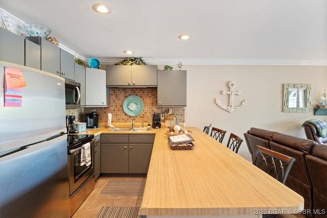 kitchen featuring stainless steel appliances, gray cabinetry, tasteful backsplash, crown molding, and sink