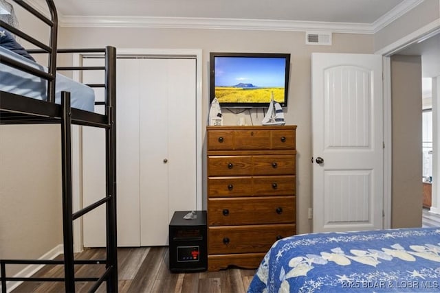 bedroom featuring a closet, ornamental molding, and dark hardwood / wood-style floors