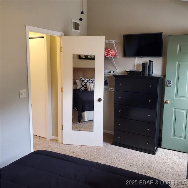 bedroom featuring visible vents and light colored carpet