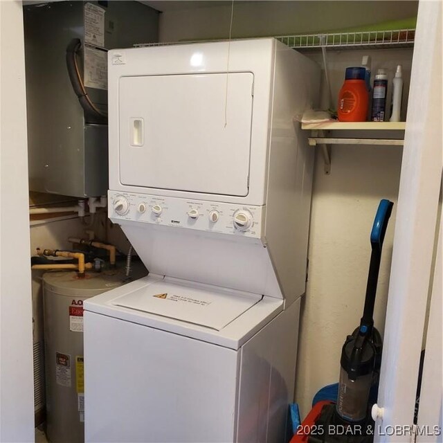 laundry room with water heater, stacked washer and dryer, and laundry area