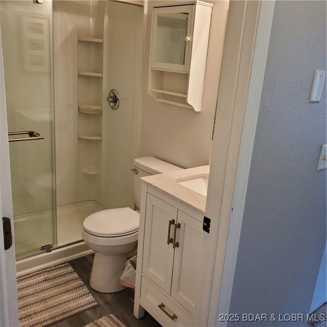 full bath with vanity, wood finished floors, toilet, and a shower stall