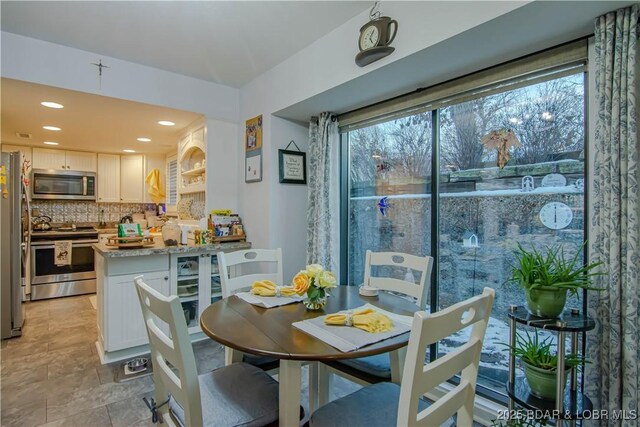 dining area featuring stone finish flooring and recessed lighting