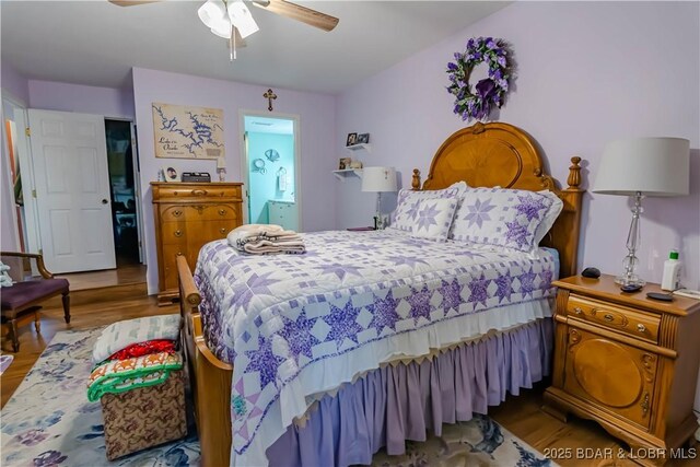 bedroom with light hardwood / wood-style floors, ensuite bath, and ceiling fan