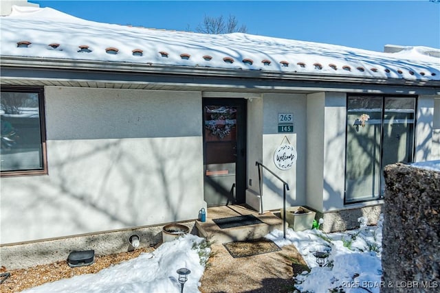 view of side of property featuring stucco siding and a tile roof