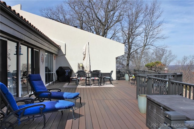 wooden deck featuring a grill and outdoor dining area