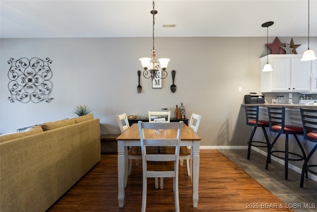 dining room featuring dark hardwood / wood-style flooring and an inviting chandelier