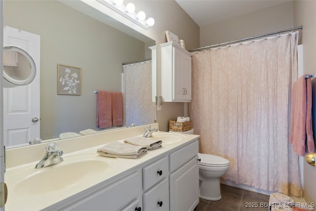 bathroom with toilet, vanity, and tile patterned flooring