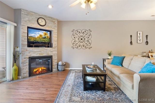 living room with ceiling fan, a fireplace, and wood-type flooring