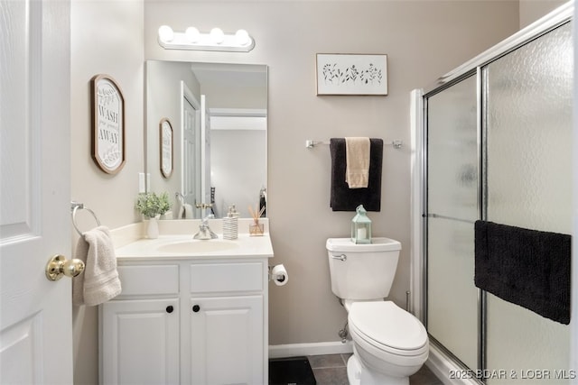 bathroom featuring toilet, tile patterned flooring, walk in shower, and vanity