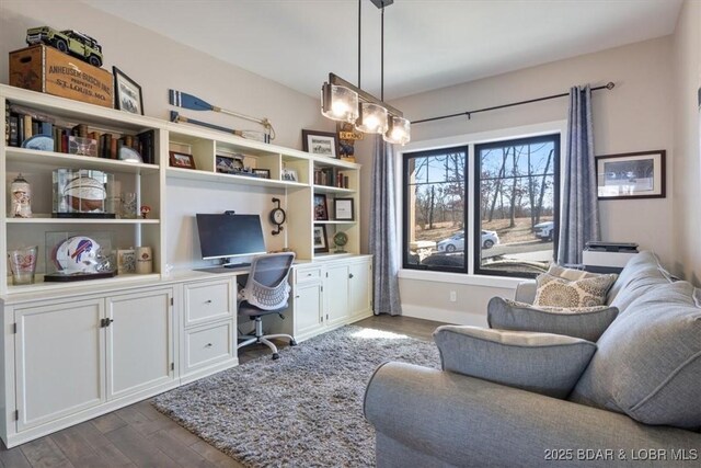 office space with built in desk and wood-type flooring