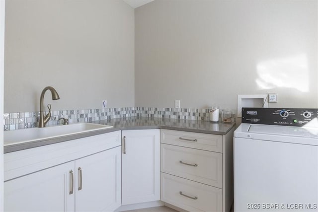 washroom featuring sink, cabinets, and washer / dryer