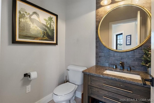 bathroom with backsplash, toilet, and vanity