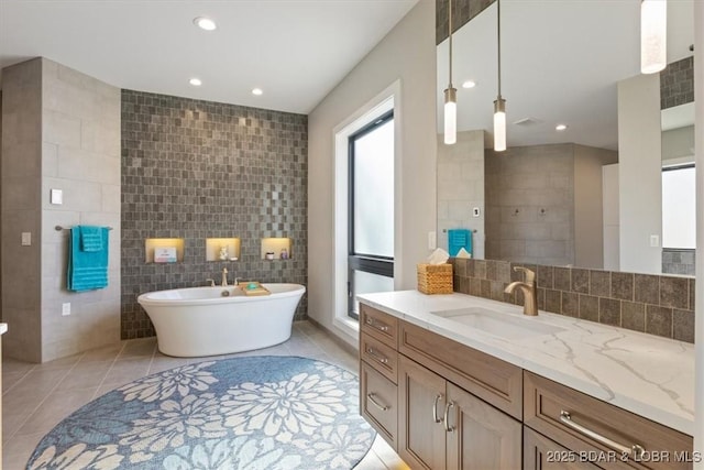 bathroom featuring tile walls, tile patterned floors, vanity, and a bathing tub