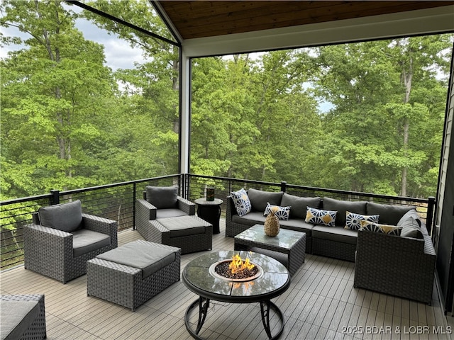 wooden deck with an outdoor living space with a fire pit