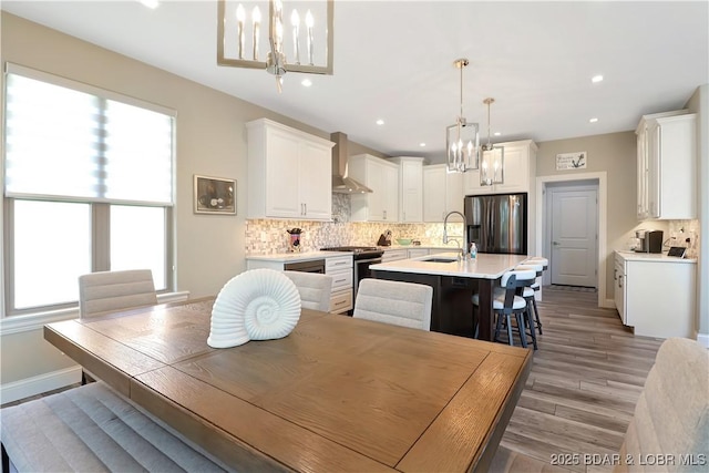 dining room with sink, light hardwood / wood-style flooring, and an inviting chandelier