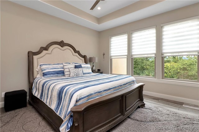 bedroom with ceiling fan, multiple windows, and light wood-type flooring