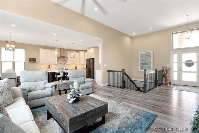 living room featuring a notable chandelier, french doors, and light hardwood / wood-style flooring