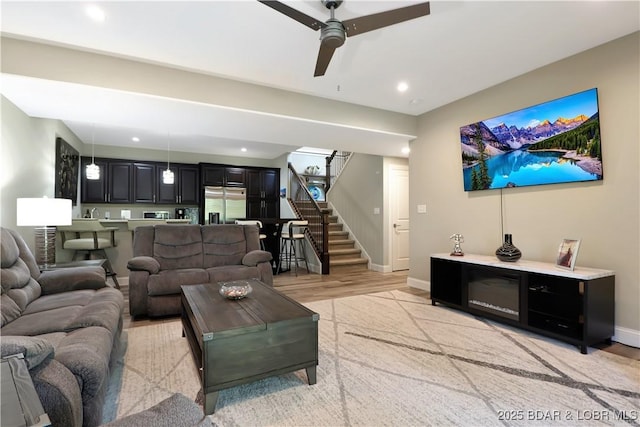 living room with light wood-type flooring and ceiling fan