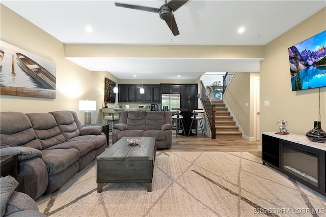 living room featuring ceiling fan and light hardwood / wood-style floors