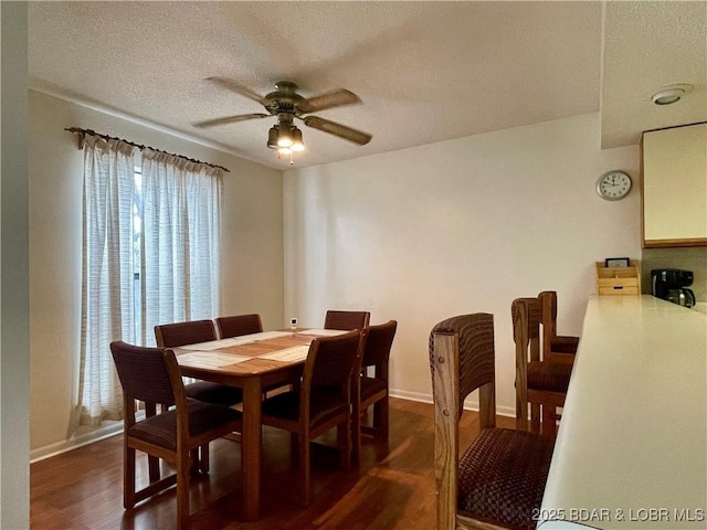 dining space featuring ceiling fan, dark wood-type flooring, and a textured ceiling